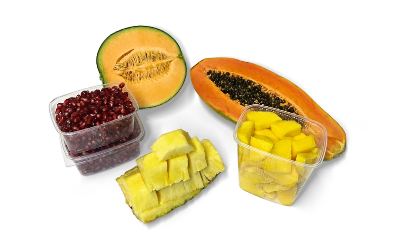 Halbe Melone und Papaya, Granatapfelkerne, Ananasstücke und Mangowürfel